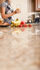 Image showing Young Woman Holding Glass of Orange Juice