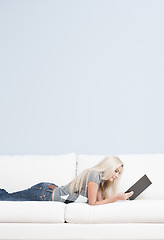 Image showing Woman Reclining on Couch With Book