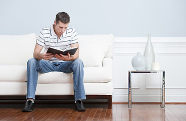 Image showing Man Reading on Living Room Couch