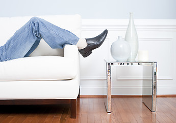 Image showing Man's Legs Reclining on White Couch