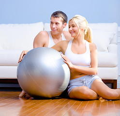 Image showing Couple Sitting on Floor With Silver Exercise Ball