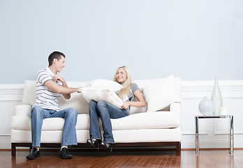 Image showing Young Couple Having a Pillow Fight on Sofa