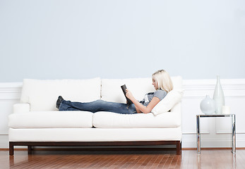 Image showing Woman Reclining on Couch With Book