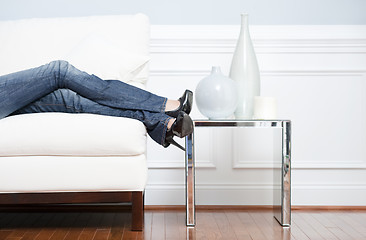 Image showing Woman's Leg's Reclining on White Couch