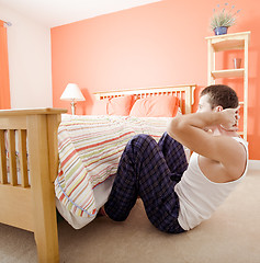 Image showing Man Doing Sit-Ups in Bedroom