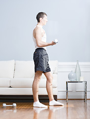 Image showing Man Using Arm Weights in Living Room