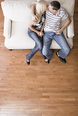 Image showing Young Couple Sitting on Love Seat Kissing