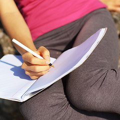 Image showing Girl Writing in Note Book