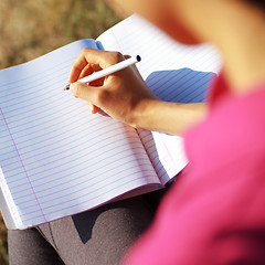 Image showing Girl Writing in Note Book