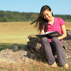 Image showing Girl Writing in Note Book