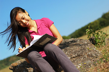 Image showing Girl Writing in Note Book