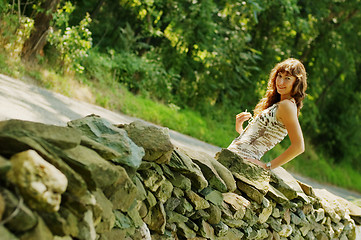 Image showing Pretty Girl Next to Stone Fence