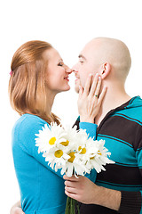 Image showing Couple kissig holding flowers