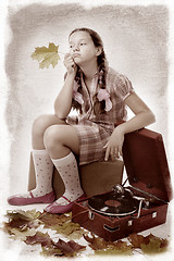 Image showing  kid sitting holding maple leaf with gramophone