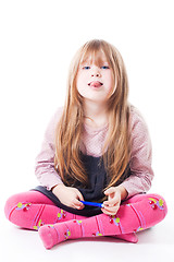 Image showing Little girl sit with stick her tongue out