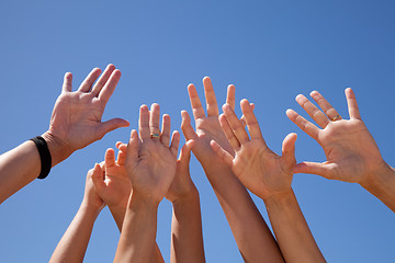 Image showing hands raised to the sky