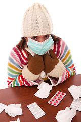 Image showing woman sneezing to a tissue