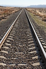 Image showing Straight railway in the desert converging to the horizon