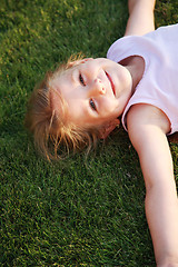 Image showing Happy girl relaxing on a grass