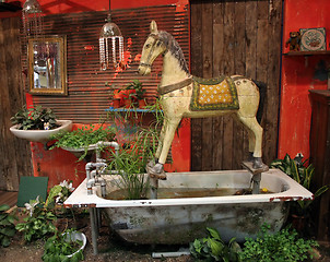 Image showing Antique wooden horse set in old bathtub