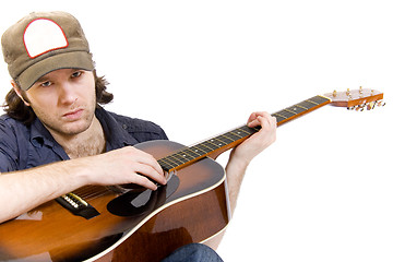 Image showing guitarist playing an acoustic guitar seated