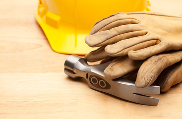 Image showing Yellow Hard Hat, Gloves and Hammer on Wood