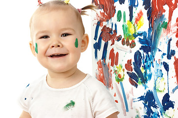 Image showing Happy little girl and her paintings