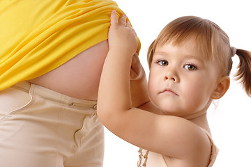 Image showing Daughter looking at pregnant mother's belly