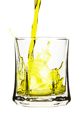 Image showing Splash, yellow drink is being poured into glass