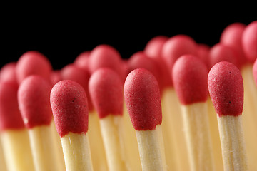 Image showing Line of red matchsticks on black background