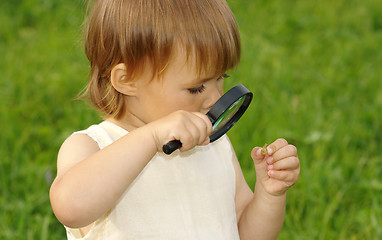 Image showing Child looking at snail through magnifying glass