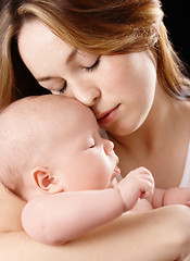 Image showing Mother holds her dreaming child