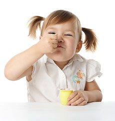 Image showing Funny Little girl eats yogurt