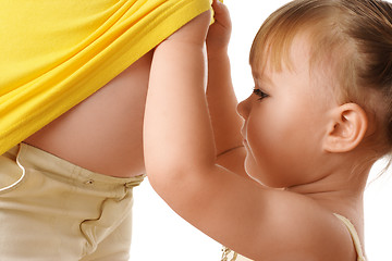 Image showing Daughter looking at pregnant mother's belly