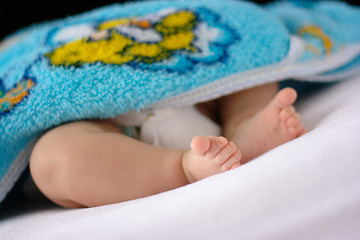 Image showing Adorable toddler's feet on white bedsheet