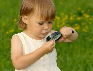 Image showing Child looking at snail through magnifying glass