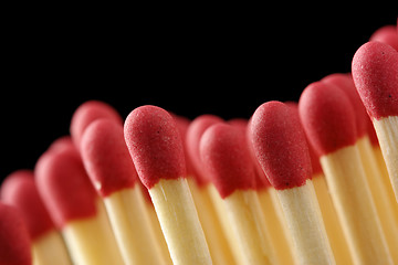 Image showing Wave of red matchsticks on black background