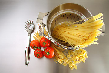 Image showing Overhead shot of pasta, tomatoes and pot on stainless steel