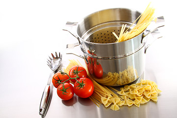 Image showing Cooking pot with uncooked pasta and tomatoes