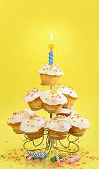 Image showing Cupcakes with blue candle on yellow