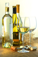 Image showing Bottles of white wine with glasses 