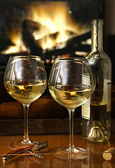 Image showing White wine in front of a warm fire