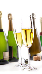 Image showing Glasses of champagne with bottles on white