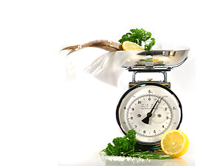 Image showing Weight scale, fish,lemon on parchment paper 