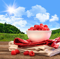 Image showing Bowl of raspberries on rustic table 