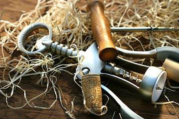 Image showing Cork screws laying on oak table 