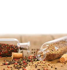 Image showing Bottles of spices on rustic table 