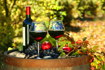 Image showing Glasses of red wine on old barrel