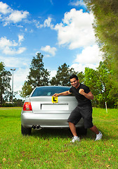 Image showing Happy male driver holding learner licence plates beside car