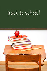 Image showing Old school desk with a stack of books